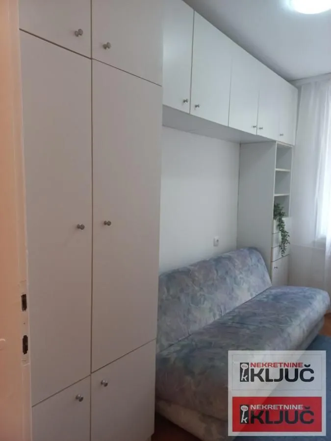 Manja dnevna soba sa kaučem i ugradnim ormarima.