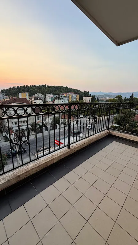 Prostrana terasa sa pločicama i pogledom na grad.