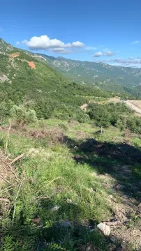 Zeleni plac u prirodi sa pogledom na planine. - image 3