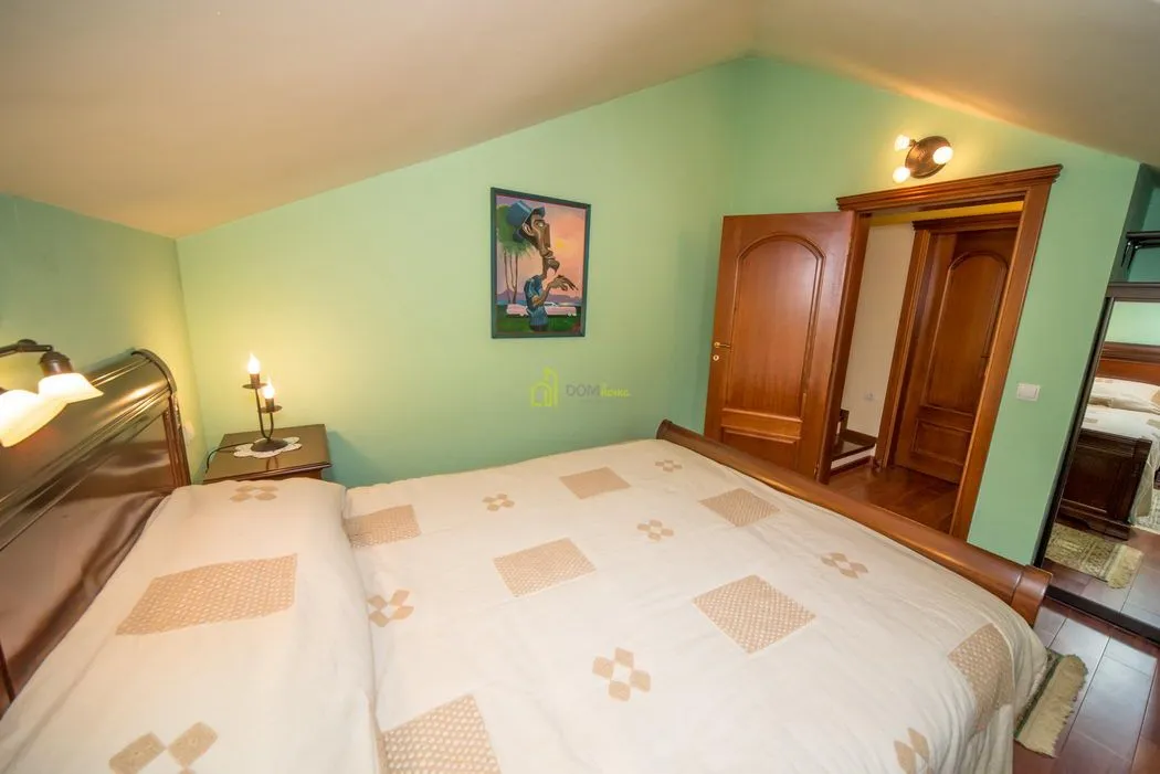 Furnished bedroom with a double bed and green walls.