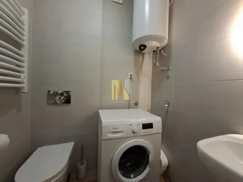 Manje kupatilo obloženo sivim pločicama sa veš mašinom i bojlerom. - image 8