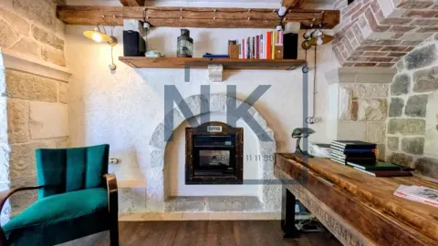 Living room with a fireplace, wooden beams, and traditional stone details. - image 3