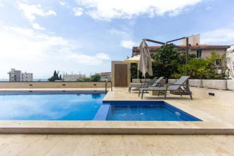 Swimming pool with sun loungers and an umbrella on the building terrace. - image 6