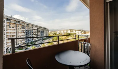 Furnished balcony with a table and chairs and a city view. - image 12