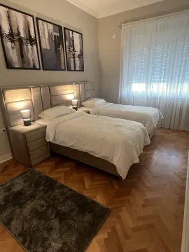 Bright bedroom featuring two single beds and parquet flooring. - image 9