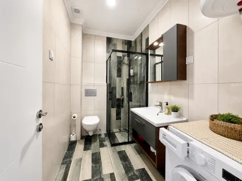 Modern bathroom equipped with a shower cabin and washbasin. - image 7