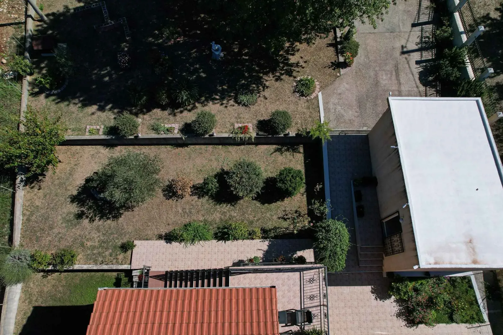 Pogled iz vazduha na dvorište i kuću sa popločanim dijelom.