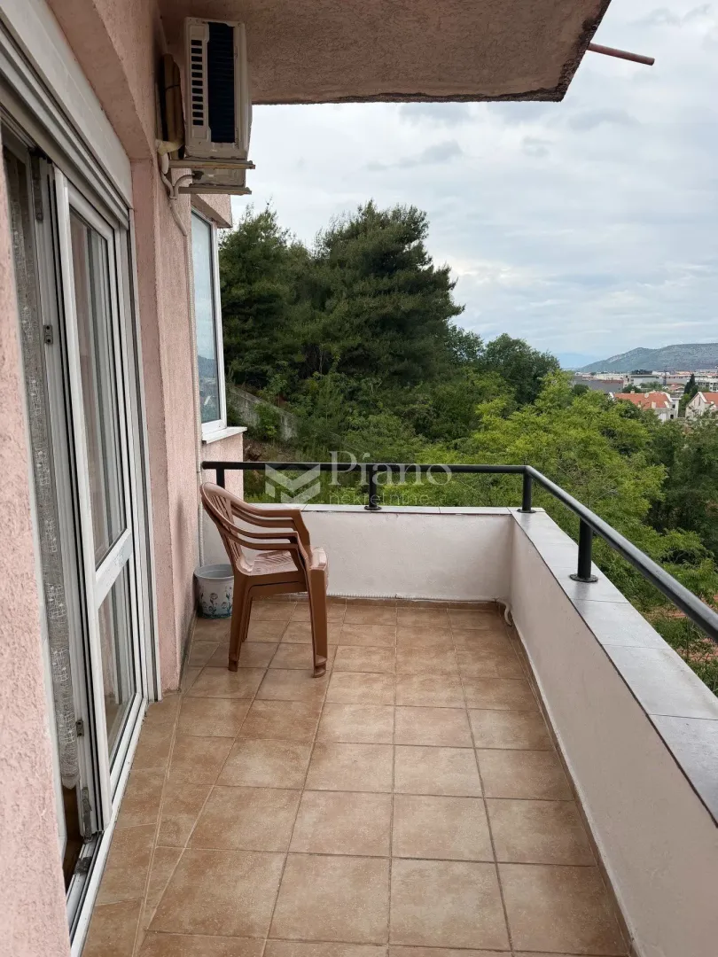 Natkriveni balkon sa pogledom na zelenilo i okolinu.