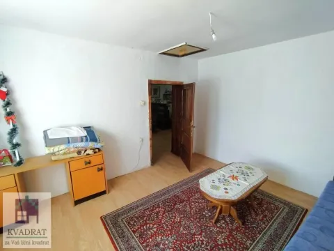 Manja opremljena soba sa tepihom i drvenim stočićem. - image 12