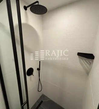 Modernly equipped bathroom with a shower cabin and black fixtures. - image 13