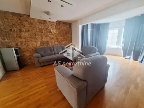 Living room with seating furniture and a stone wall. - image 2