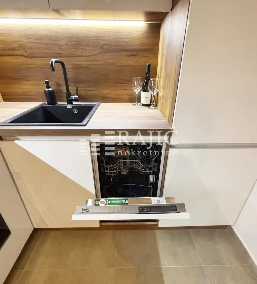 Modern kitchen with a sink and an open dishwasher.