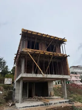 View of a house under construction with concrete structure and scaffolding. - image 9