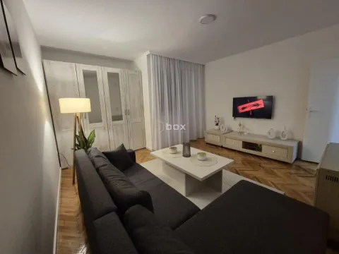 Dnevna soba sa garniturom, TV-om i belim ormarom. - image 4