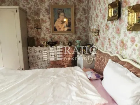 Furnished bedroom with a double bed and patterned wallpaper. - image 12