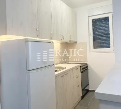 Small kitchen with light wood cabinets and a white refrigerator. - image 5
