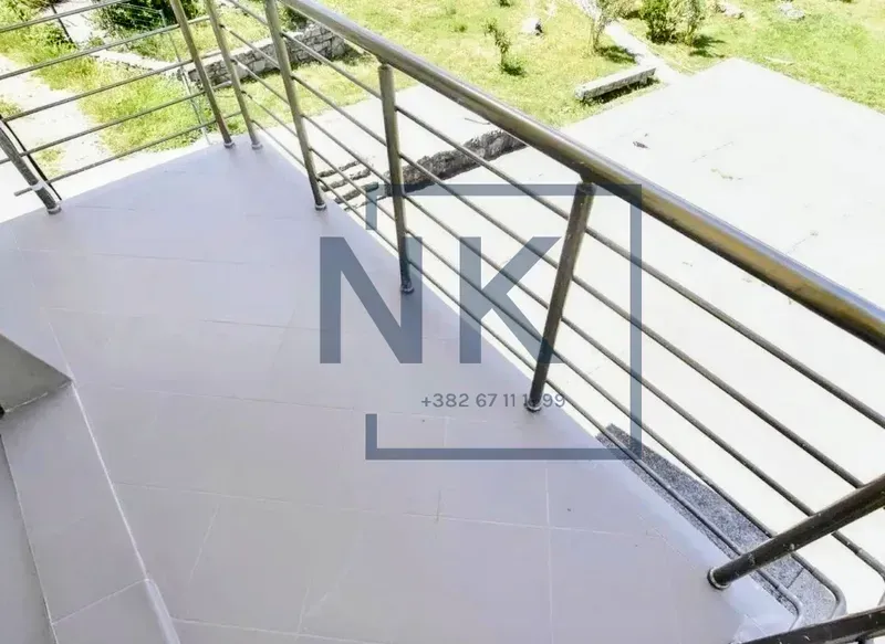 Tiled balcony with metal railing and a view of the courtyard.