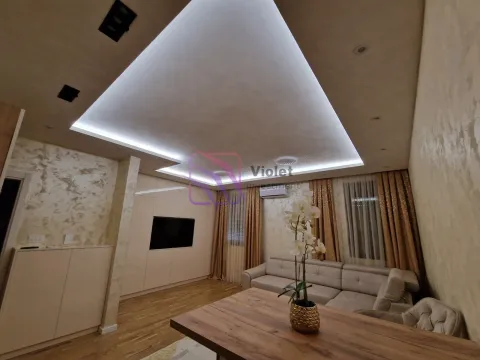 Living room with a sofa set, dining table, and dropped ceiling with LED lighting. - image 3