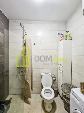 Smaller bathroom with a shower cabin, toilet, and washing machine. - image 14