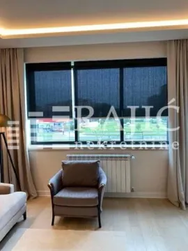 Living room with an armchair and a large window. - image 11