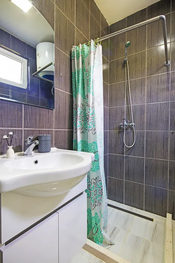 Bathroom with a washbasin, mirror, and a shower with a curtain.