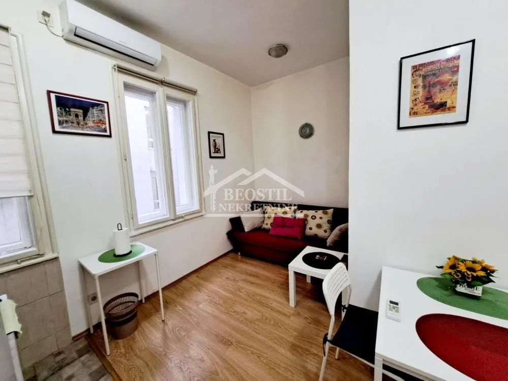 Manja dnevna soba sa garniturom i trpezarijskim stolom.