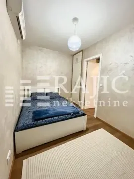 Small bedroom with a double bed, wardrobe, and air conditioning. - image 9