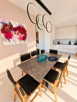 Dining area with a modern table and chairs connected to the kitchen. - image 8