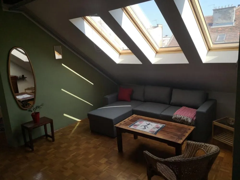 Attic living room with sofa and roof windows.