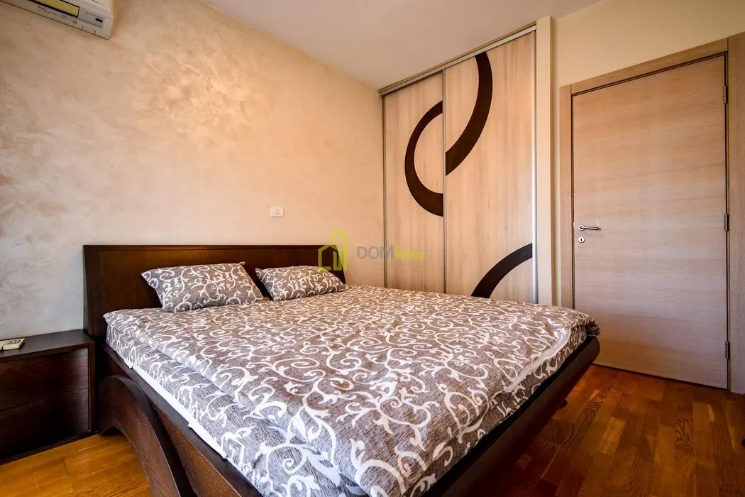 Furnished bedroom with a double bed, fitted wardrobe and parquet flooring.