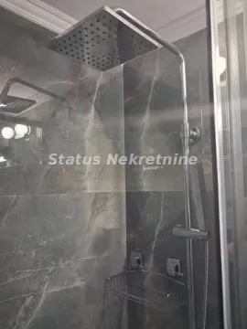 Tuš kabina sa modernom slavinom i tamnim pločicama u kupatilu. - image 10
