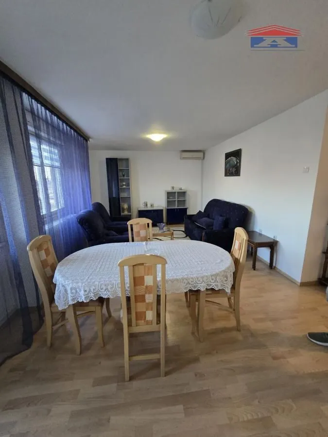 Dnevni boravak sa trpezarijskim stolom i garniturom za sedenje.