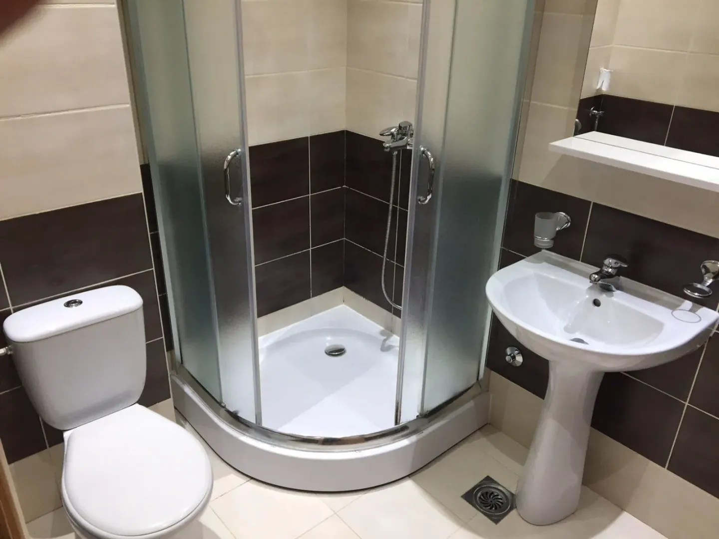 Bathroom equipped with a shower cabin, washbasin, and toilet.