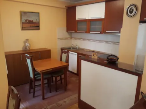 Kuhinja sa trpezarijom opremljena drvenim elementima i stolom sa stolicama. - image 4