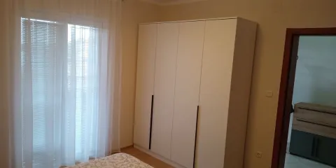 Bedroom with a large white wardrobe and a window with curtains. - image 5