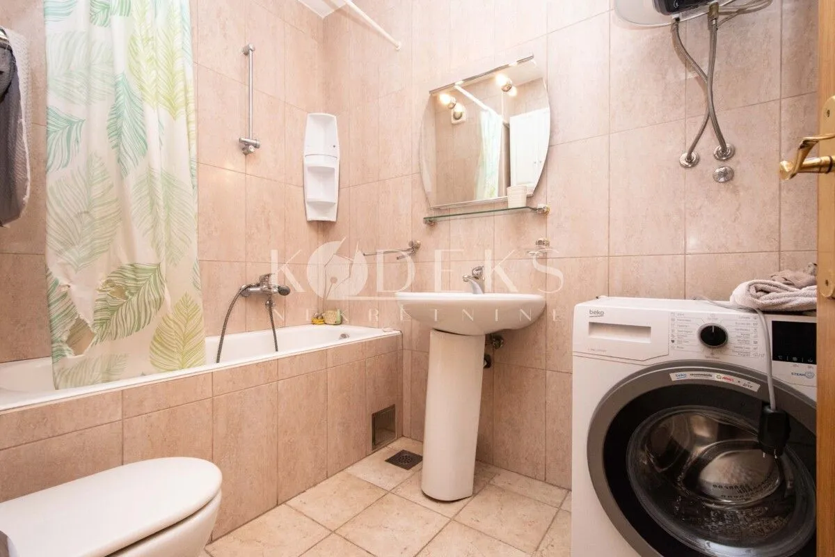 Bathroom equipped with a bathtub, sink, toilet, and washing machine.
