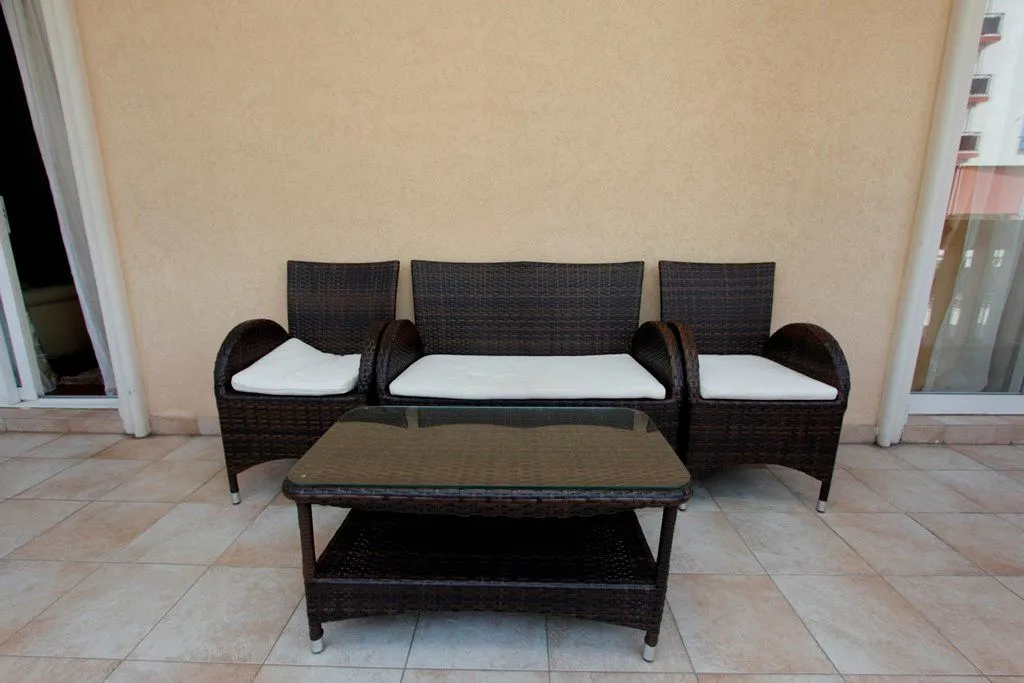 Rattan furniture set with a table on a spacious terrace.