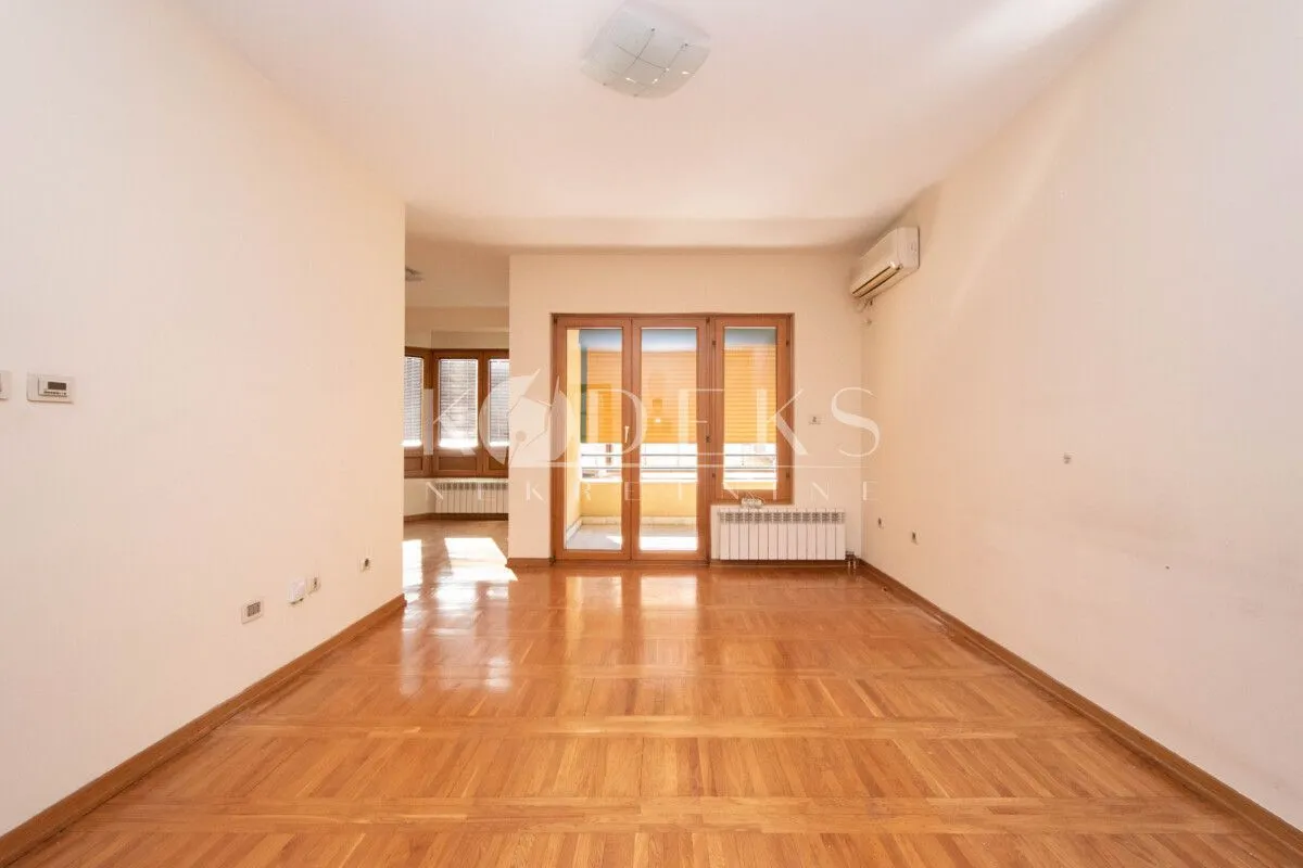 Empty living room with parquet flooring and access to the terrace.