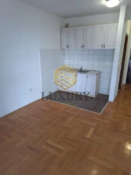 Small kitchen with white cabinets and parquet flooring. - image 2