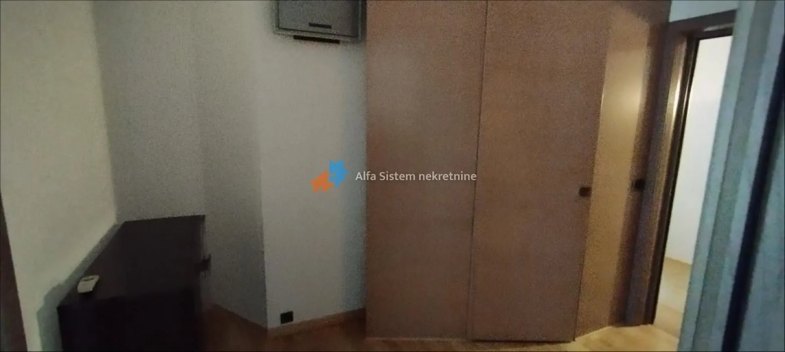 Pogled na spavaću sobu sa ormarom i TV-om.