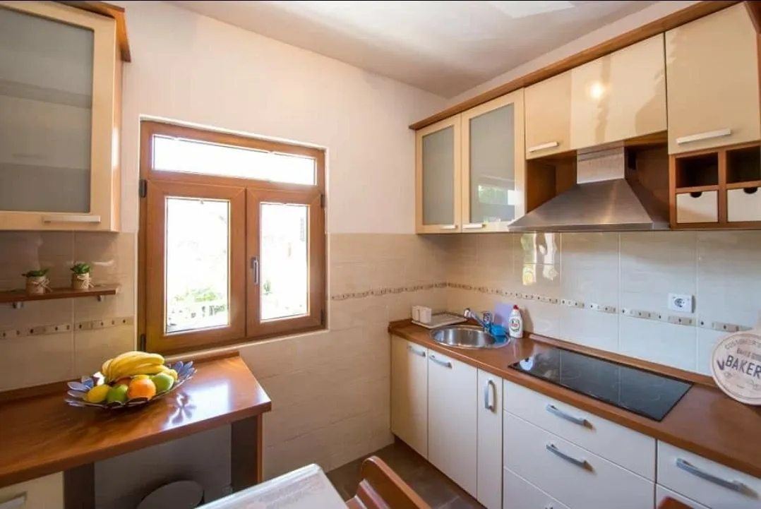 Kitchen with wooden cabinetry and a window overlooking outside.