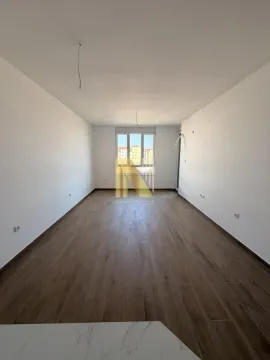 Prazna neopremljena prostorija sa belim zidovima i drvenim podom. - image 2