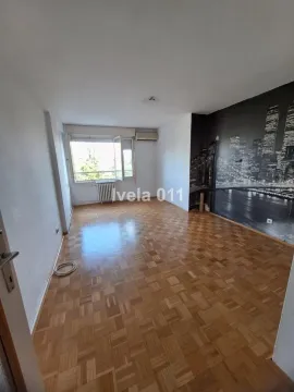 Empty room with parquet flooring and a city skyline wallpaper on the wall. - image 3