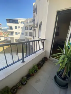 Manji popločani balkon sa ukrasnim biljem u saksijama i pogledom na susjedne zgrade. - image 9