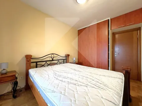 Spavaća soba sa bračnim krevetom, drvenim ormarom i noćnim stočićima. - image 6