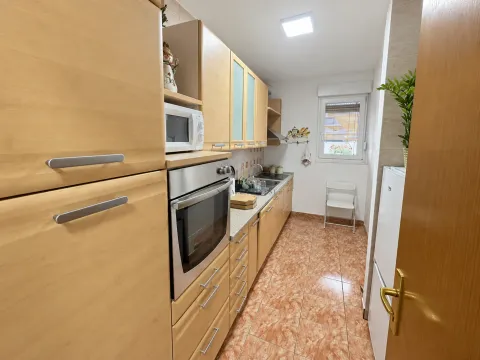 Small kitchen with wooden cabinetry and a built-in oven. - image 6