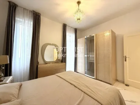 Furnished bedroom with a double bed, wardrobe, and dresser with a mirror. - image 12