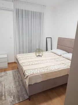 Furnished bedroom with a double bed and a window with curtains. - image 7