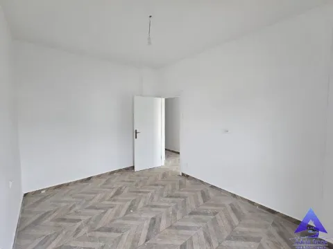 Prazna neopremljena soba sa bijelim zidovima i podom obloženim pločicama u dezenu drveta. - image 4