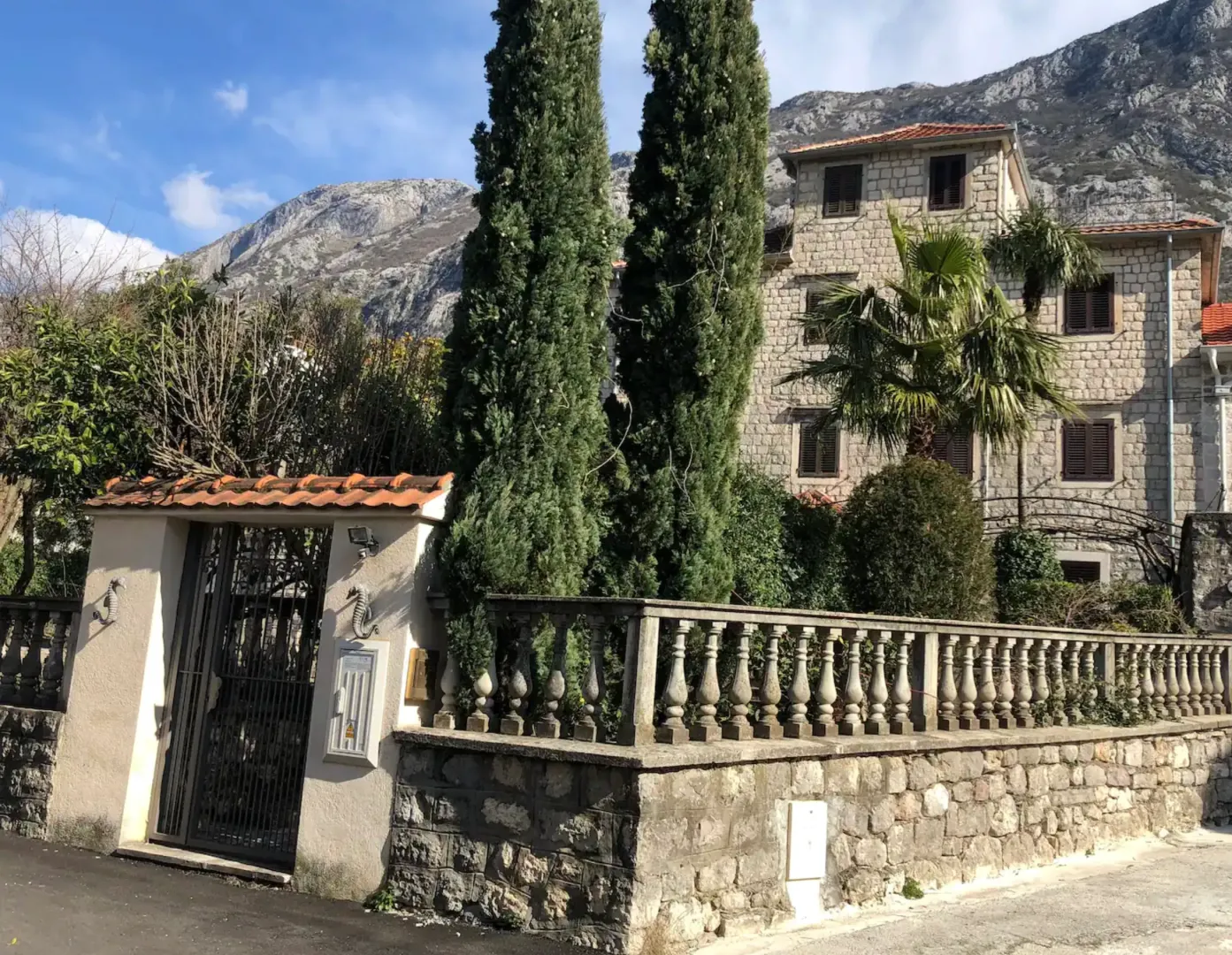 Eksterijer tradicionalne kamene kuće sa ogradom i dvorištem.